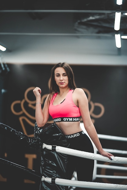 Спортивная девушка стоит на боксерском ринге