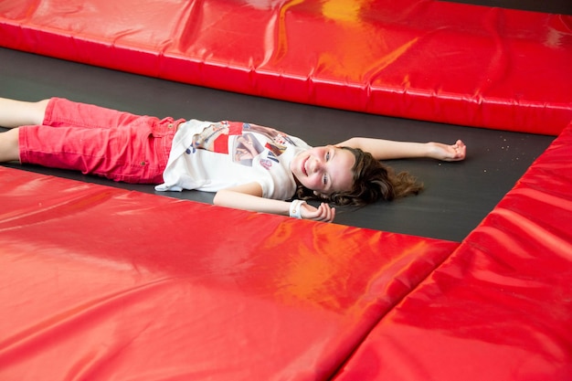 Photo sports girl jumps on a trampoline happy summer vacation