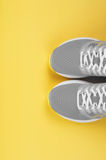 Sports gray sneakers on a yellow