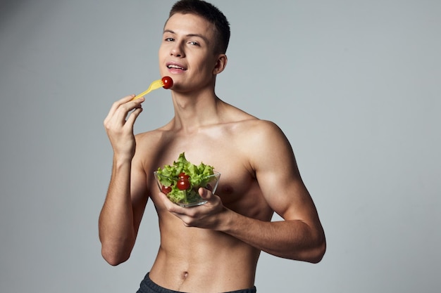 Sports guy eating salad healthy food energy workout isolated background High quality photo