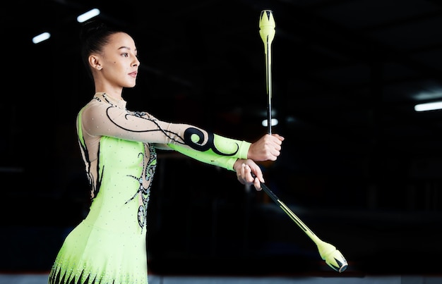 Sports gymnastics and woman with clubs for performance rhythmic body movement and training Aerobics exercise health and female dancer with equipment for competition workout and dance practice