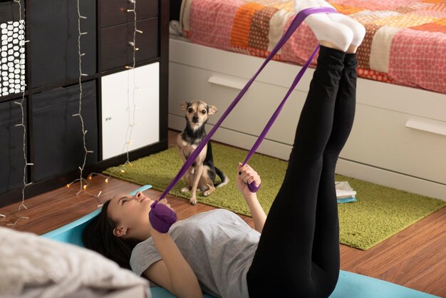 Sports at home during quarantine the girl is engaged in fitness with an elastic band lifestyle