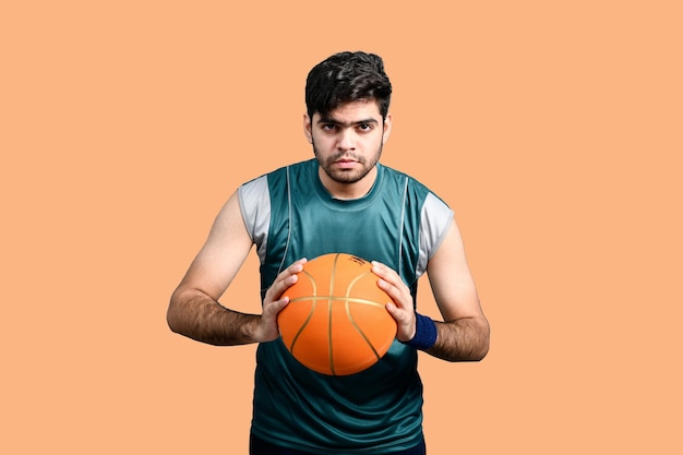 バスケットボールを保持し、正面を向いているスポーツマンインドのパキスタンモデル