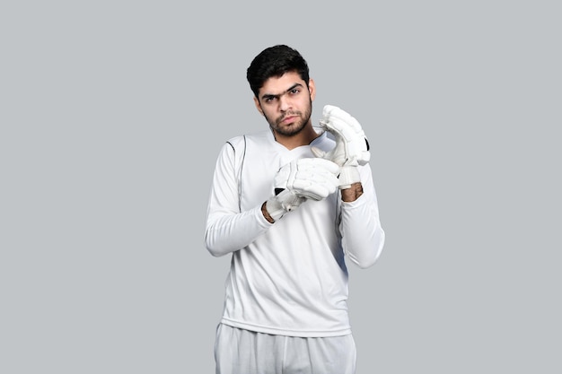 sports man touching cricket gloves and looking front indian pakistani model