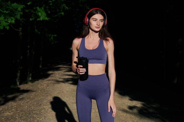 A sports model poses outside A young woman after a workout