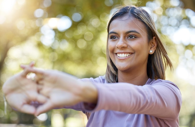 Foto sport natura e donna che fanno un allenamento di stretching prima di un allenamento nel parco o in giardino benessere fitness e atleta femminile che fa esercizio di riscaldamento del braccio prima dell'allenamento di pilates all'aperto sul campo