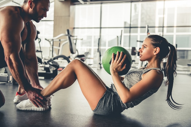 Sports people are working out with fitness balls in gym.