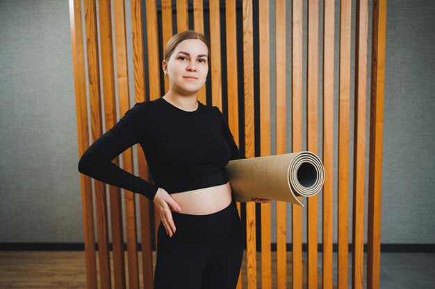 Sports during pregnancy Cheerful young pregnant woman doing sports on a sports mat Healthy lifestyle during pregnancy