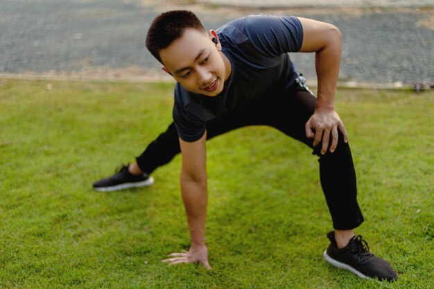 Sports and recreation concept a male adolescent doing warm-up movements as raising his body temperature and increasing blood flow to his muscles.