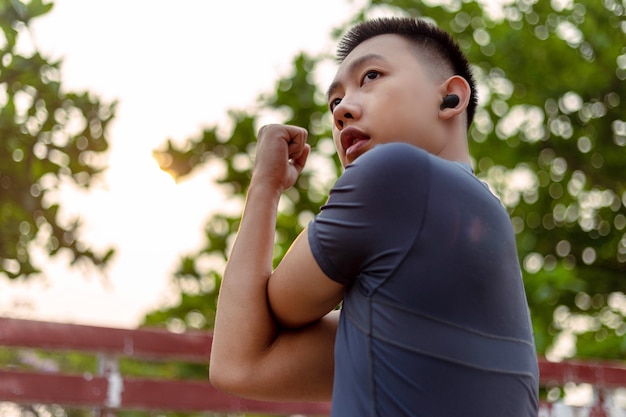 Photo sports and recreation concept a male adolescent doing warm-up movements as raising his body temperature and increasing blood flow to his muscles.