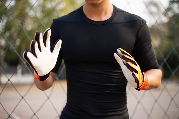 Foto concetto di sport e ricreazione un giocatore dilettante maschio che si esercita come posizione di portiere che prova a prendere la palla.