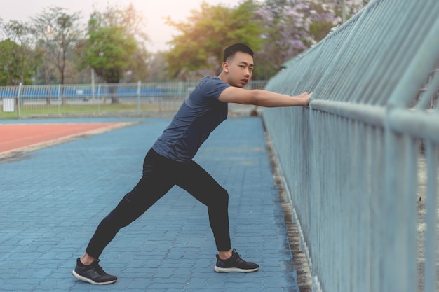 Sports and recreation concept a male youth doing warm-up by stretching each part of his body as preparation before exercise.