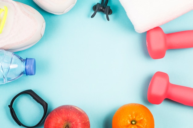 Sports shoes, dumbbell fitness in the blue background. Different sports tools