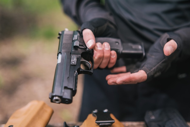 スポーツ射撃インストラクターが武器のクローズアップをチェック