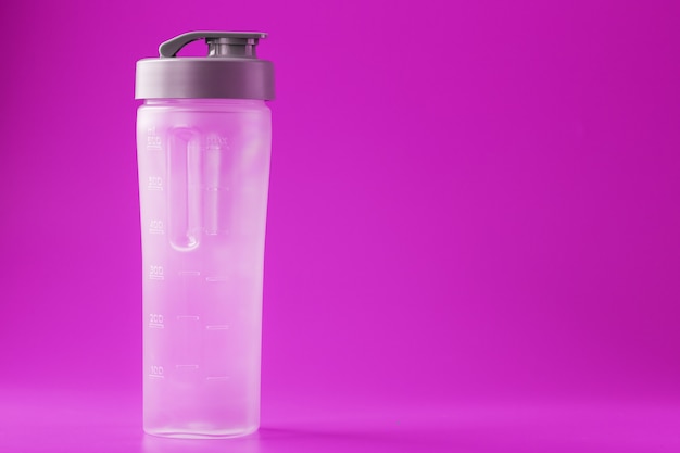 Sports smoothie bottle on pink surface