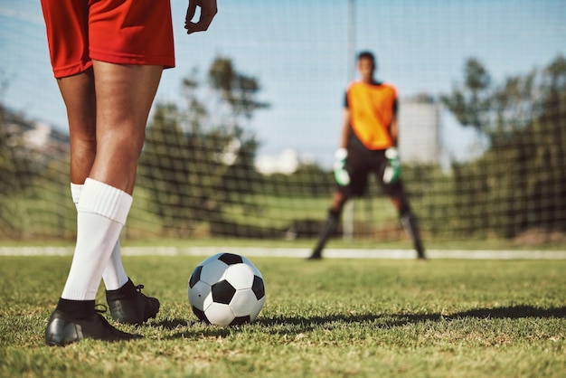 Sports soccer field and legs of athlete with goalkeeper ready for penalty kick game or competition for fitness health Football player ball or man prepare for outdoor workout training or exercise