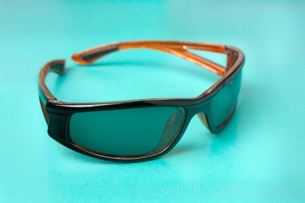 Sports sunglasses on green background copy space