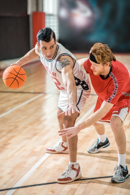 Sports. two young men playing basketball and feeling\
excited