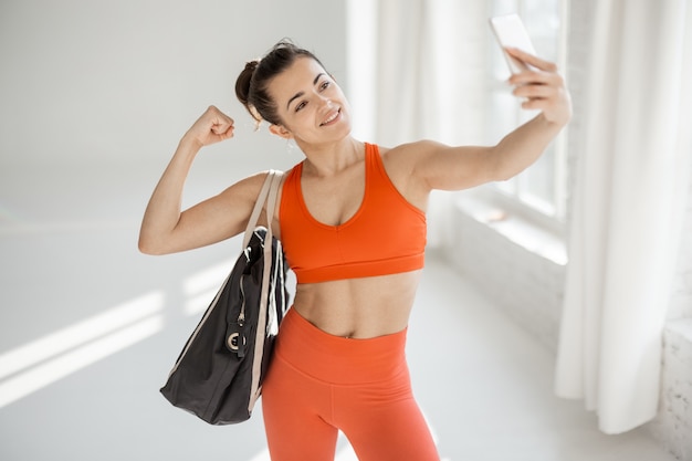 Sports woman making selfie photo at gym