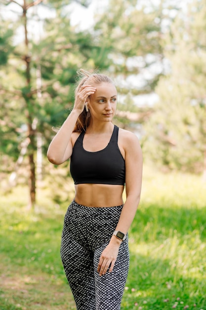 Sports woman in sportssuit doing exercises outdoors in the park