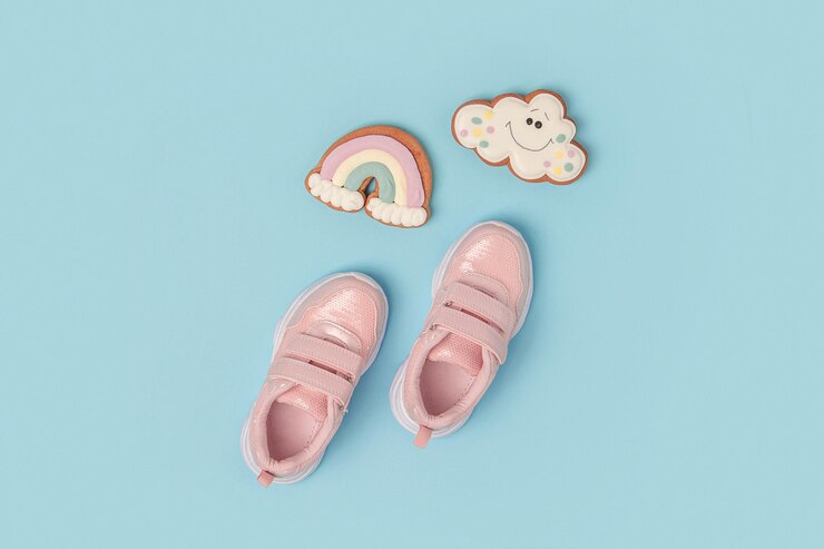Sportschoenen roze sneakers en schattige peperkoek op achtergrond zomertijd concept bovenaanzicht plat lag