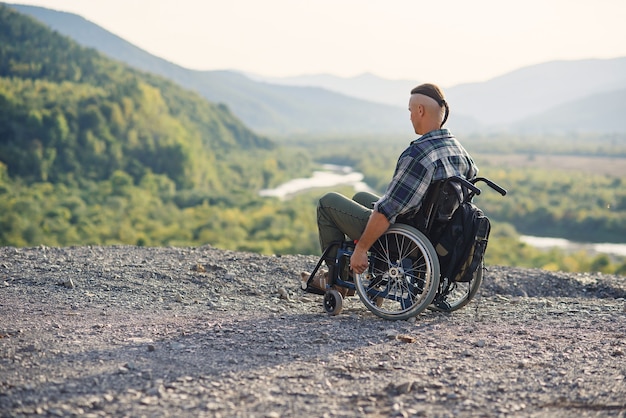 Sportsman after injury in wheelchair enjoy fresh air in the mountains