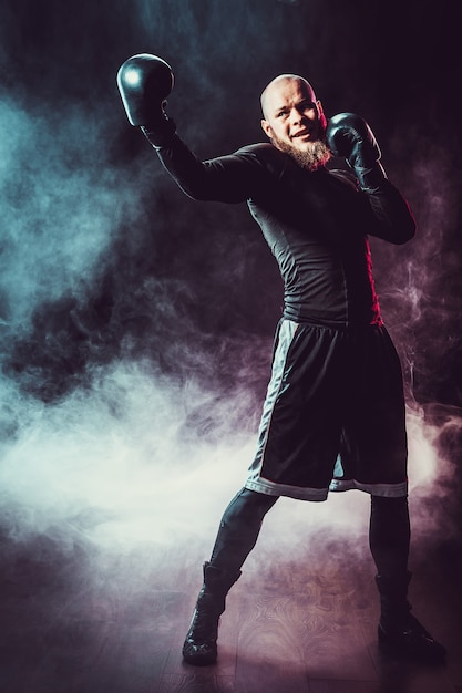 Sportsman boxer fighting on black space with smoke