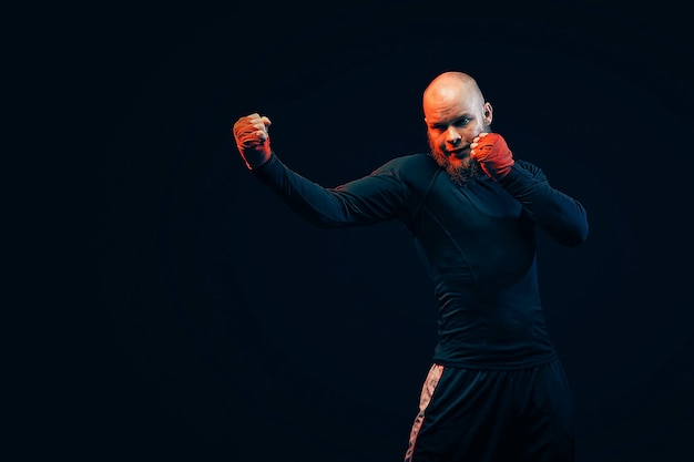 Photo sportsman boxer fighting on black wall