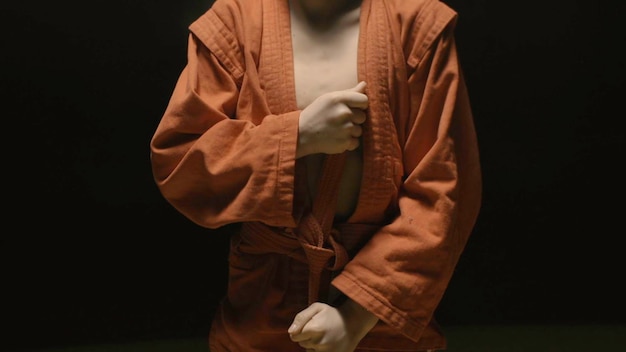 Photo sportsman boy in a red kimono for judo boy puts on a red kimono in preparation for training or