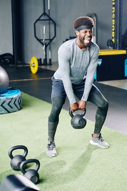 Sportsman doing deep squat with kettlebell