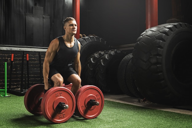 Photo sportsman doing farmer's walk exercise during his cross training workout