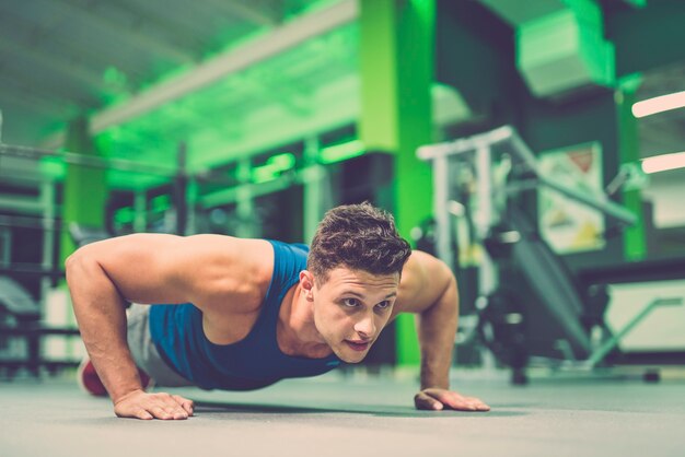 The sportsman doing push up exercise in the gym