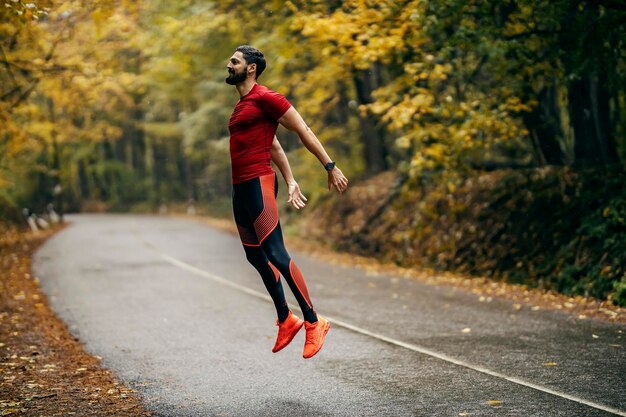 Foto uno sportivo sta saltando in natura e facendo allenamenti in un tempo piovoso