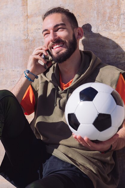 Photo sportsman laughing and talking by phone