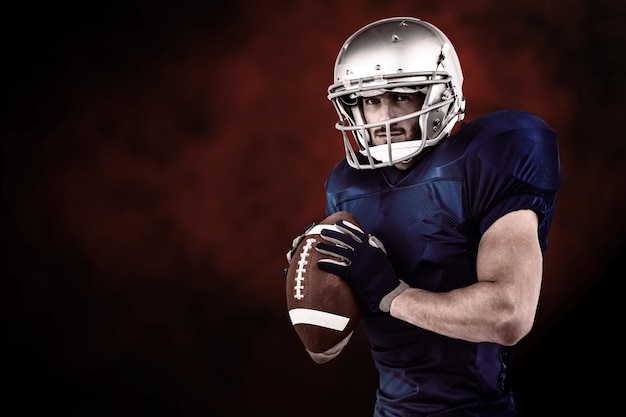 Sportsman ready to throwing the ball against dark background