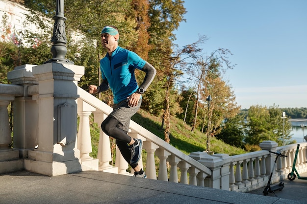 A sportsman running upstairs over urban background. Fitness, sport and people exercising concept