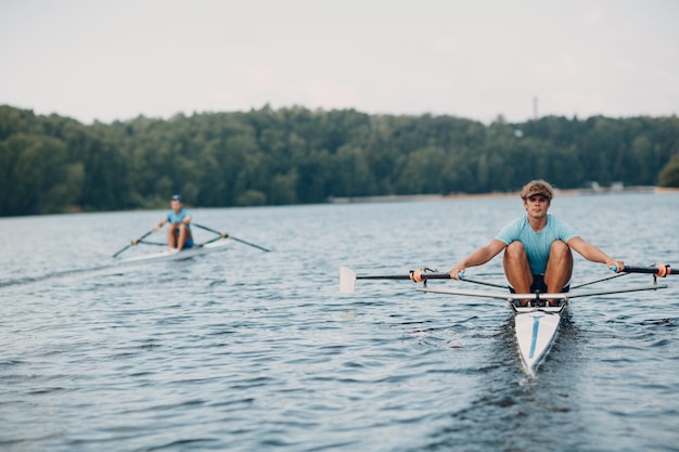 Sportsman single scull man rower rowing on boat