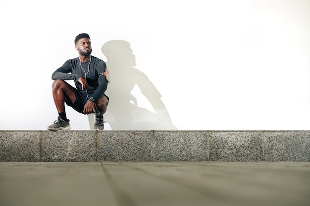 Sportsman sitting on kerb