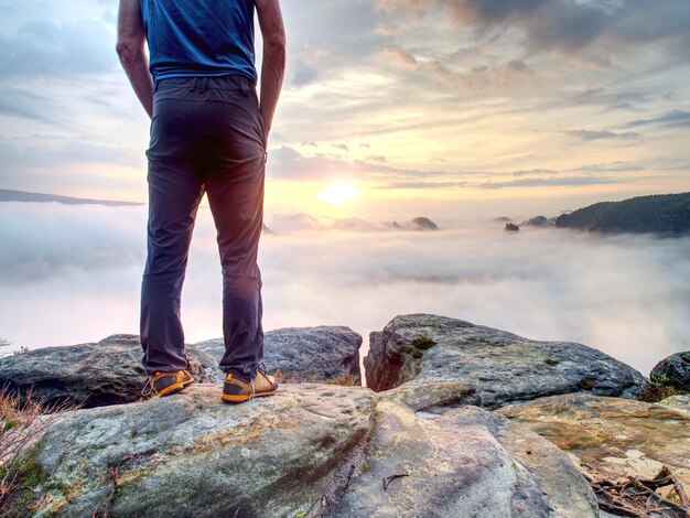 Foto sportista in piedi all'aperto e tenere le mani in tasca si sta godendo l'alba sul suo bello