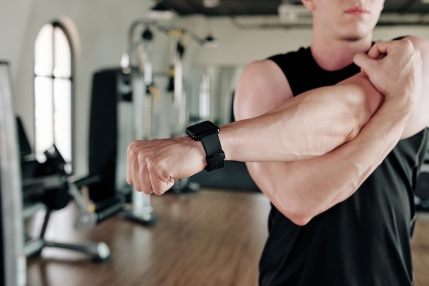 Sportsman stretching arms