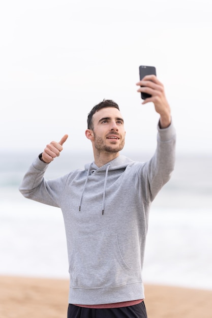 Sportsman taking selfie at the beach