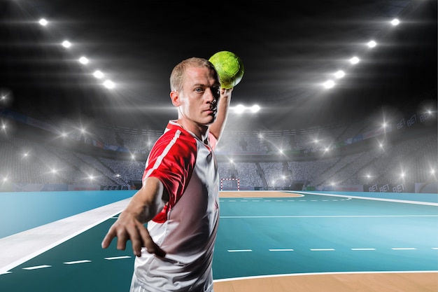 Sportsman throwing a ball against handball field indoor