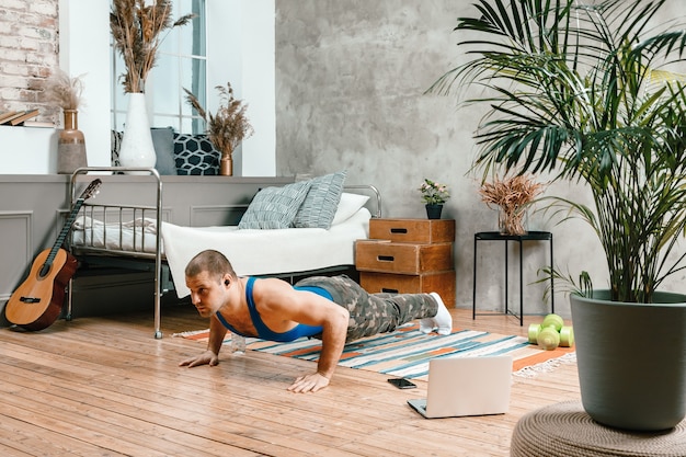 Sportsman with black hair does pushups