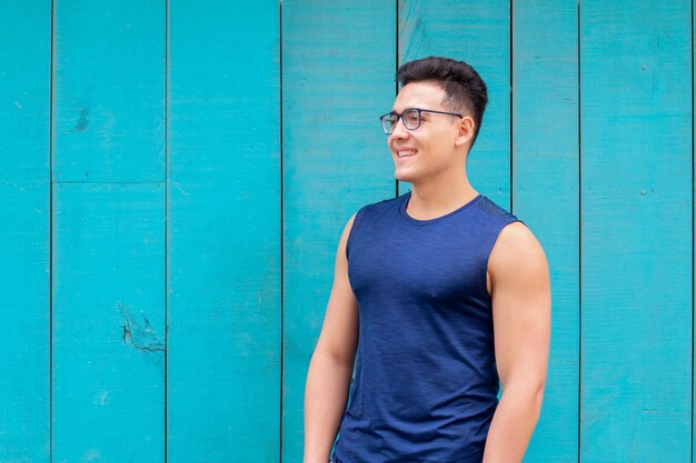 Sportsman with glasses smiling isolated on sky blue background Healthy lifestyle concept