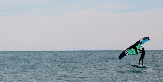Спортсмен с крыльями крыла, плывущий в море