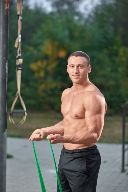 Sportsman working out outdoors with resistance bands.