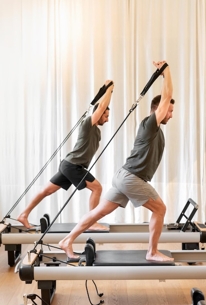 Sportsmen exercising on reformer beds