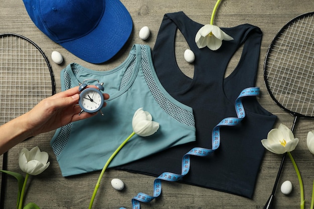 Sportswear and accessories with flowers on a wooden background