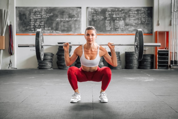 Photo sportswoman doing barbell back squat