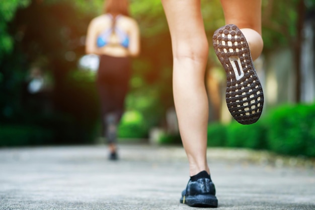 Sportswoman foot runner trail running outdoors close up on shoe behind of a man running fitness jogging workout uphill in autumn trail of nature and stones